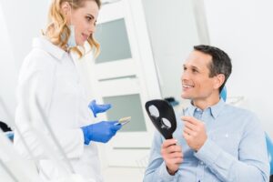 Male patient choosing tooth implant in modern dental clinic